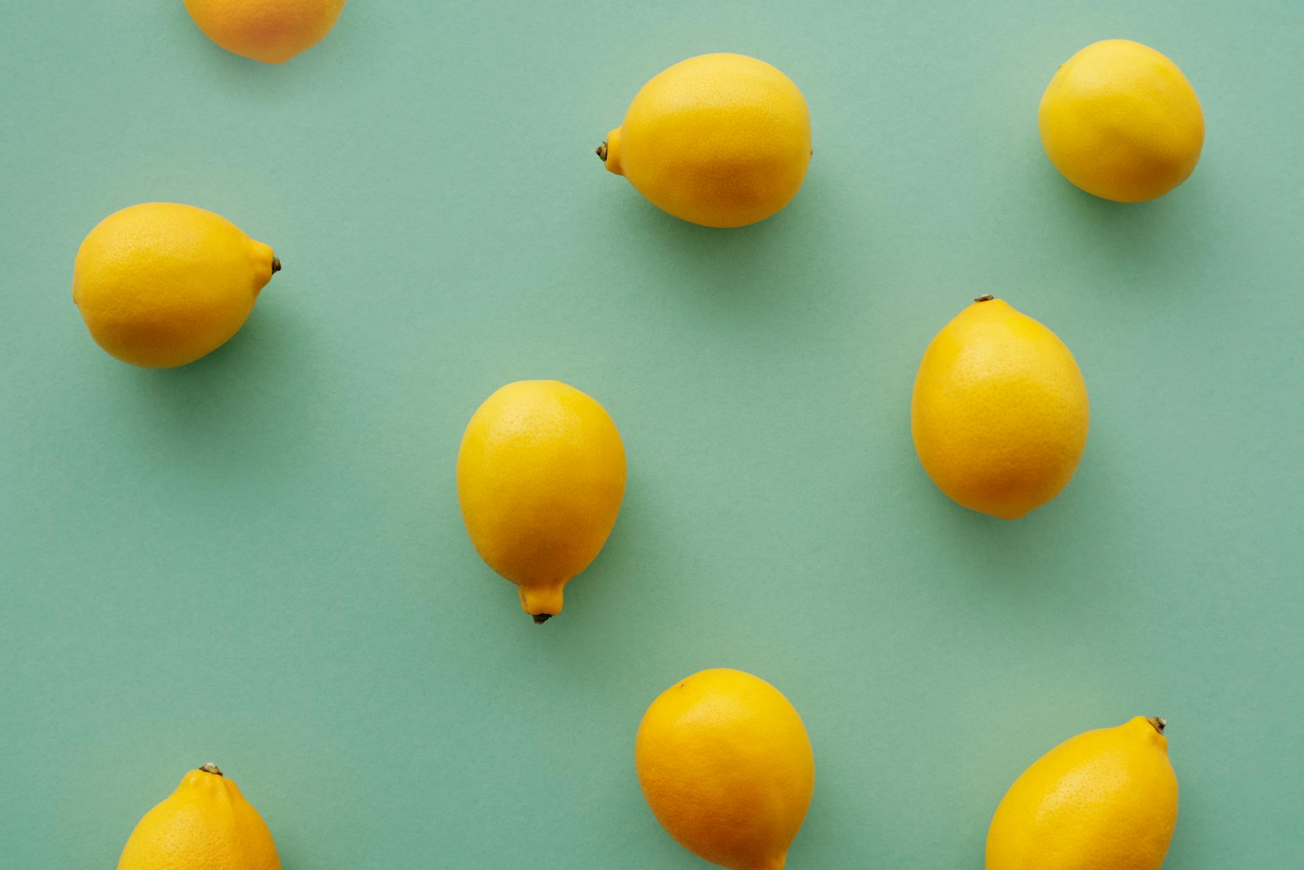 Bright yellow lemons on a pastel background, symbolizing renewed freshness and pleasure