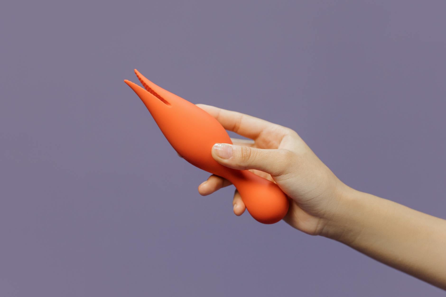A hand holding a lemon-colored vibrator against a minimalist backdrop, symbolizing gentle return to pleasure after recovery